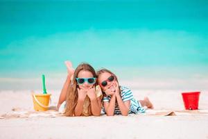 liten flickor på de strand under sommar semester foto