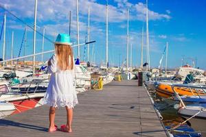 förtjusande liten flicka under sommar semester i hamn foto