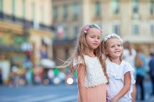 förtjusande mode liten flickor utomhus i europeisk stad foto