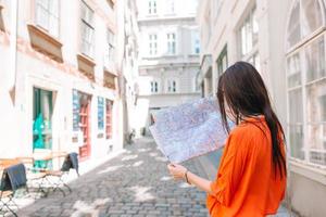 ung kvinna med en stad Karta i stad. resa turist flicka med Karta i wien utomhus under högtider i Europa. foto