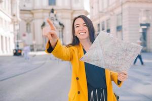 ung kvinna med en stad Karta i stad. resa turist flicka med Karta i wien utomhus under högtider i Europa. foto