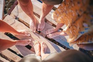 närbild av de fötter av familj på de vit sandig strand foto
