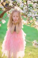 söt flicka i blomning äpple träd trädgård njut av de värma dag foto