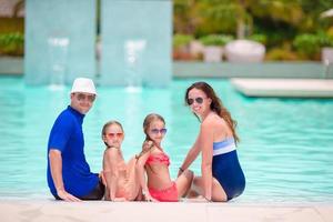 familj av fyra i utomhus- simning slå samman foto