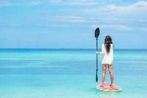 aktiv ung kvinna på stand up paddle board foto