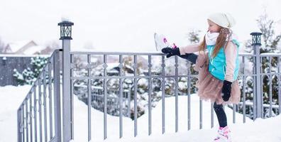 förtjusande liten flicka skridskoåkning i vinter- snö dag foto