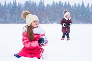 förtjusande liten flickor utomhus på vinter- snö dag foto