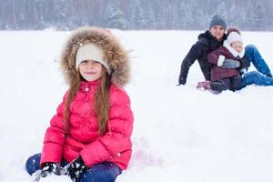 Lycklig familj ha roligt i vinter- snöig dag foto