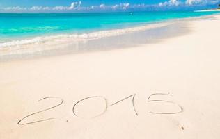 2015 skriven på tropisk strand vit sand foto