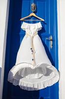 vit klänning på blå dörr i grekisk hus foto