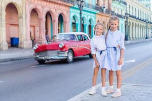 förtjusande liten flickor i populär område i gammal Havanna, kuba. porträtt av två barn utomhus på en gata av havana foto