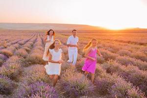 familj i lavendel- blommor fält på solnedgång i vit klänning och hatt foto