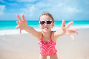 förtjusande liten flicka på strand har en massa av roligt foto