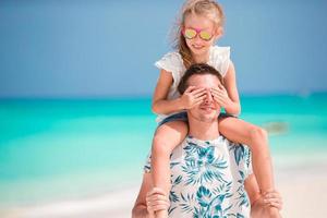 glad far och hans bedårande lilla dotter på tropisk strand har roligt foto