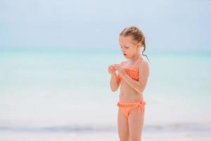 Lycklig flicka njut av sommar semester på de strand foto