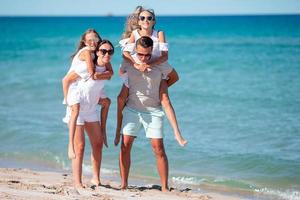 Lycklig familj på de strand under sommar semester foto