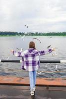 söt liten flicka utfodra seagulls foto