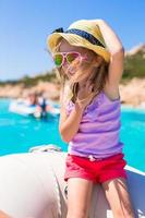 söt liten flicka njuter segling på båt under sommar semester foto