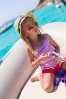 söt liten flicka njuter segling på båt i de öppen hav foto