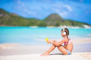 liten flicka lyssnande till musik på hörlurar på de strand foto