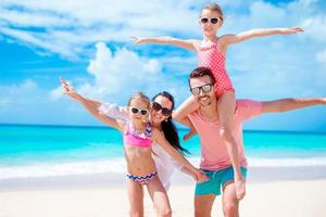 lycklig vacker familj på vit strand som har roligt foto
