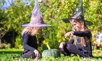 förtjusande liten flickor i häxa kostym på halloween ha roligt foto