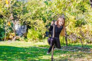 förtjusande liten flicka i halloween som kostym har roligt utomhus foto