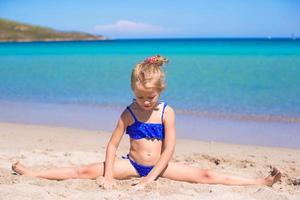 bedårande liten flicka ha kul på den tropiska stranden under semestern foto