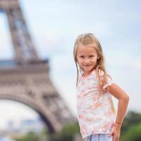 förtjusande liten flicka nära de eiffel torn under sommar semester i paris foto