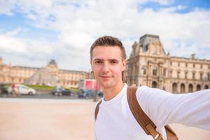 Lycklig ung man tar en selfie Foto i paris, Frankrike