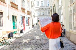 ung kvinna med en stad Karta i stad. resa turist flicka med Karta i wien utomhus under högtider i Europa. foto