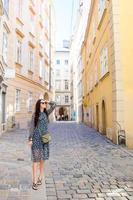 kvinna gående i stad. ung attraktiv turist utomhus i europeisk stad foto