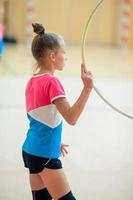 skön liten aktiva gymnast flicka med henne prestanda på de matta foto