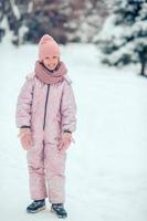 porträtt av liten förtjusande flicka i snö solig vinter- dag foto