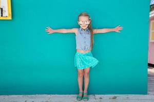 liten flicka på sommar semester bakgrund turkos vägg foto