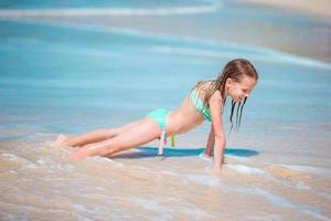förtjusande liten flicka på strand har en massa av roligt i grund vatten foto