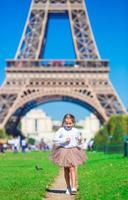 förtjusande liten flicka nära de eiffel torn under sommar semester i paris foto