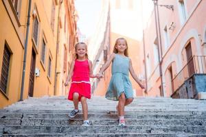 förtjusande mode liten flickor utomhus i europeisk stad foto