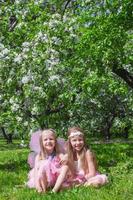 liten söt flickor i de blomstrande äpple trädgård foto