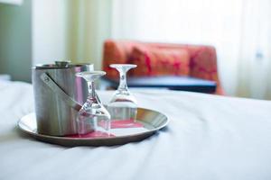 romantisk sovrum med vin glasögon och is hink i lyx hotell interiör foto