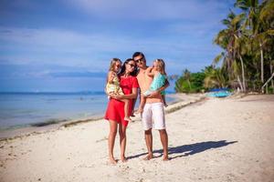 familj av fyra på strand semester foto