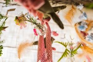 hänga fjädrar och blomma klar glas vas , artificiell blommor hänga i en bröllop fest eller interiör. dekoration inomhus foto