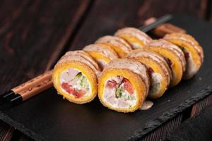 rulla med fisk sushi med ätpinnar närbild - asiatisk japansk mat begrepp foto