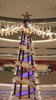 stjärna topp av jul träd dekoration och ljus på de köpcenter. foto