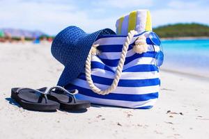 sugrör hatt, väska och handduk på vit tropisk strand foto