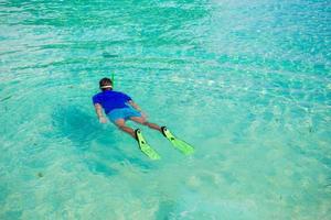 ung pojke snorkling i tropisk turkos hav foto