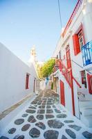de smal gator av de ö med blå balkonger, trappa och blommor i grekland. skön arkitektur byggnad exteriör med cykladisk stil. foto