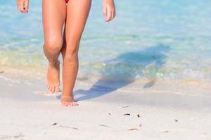 närbild fötter förtjusande liten flicka på strand foto