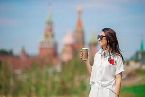 Lycklig ung urban kvinna dricka kaffe i europeisk stad. foto