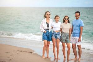 Lycklig familj på de strand under sommar semester foto